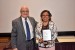 Dr. Nagib Callaos, General Chair, giving Prof. Maritza Placencia Medina a plaque "In Appreciation for Delivering a Great Keynote Address at a Plenary Session."